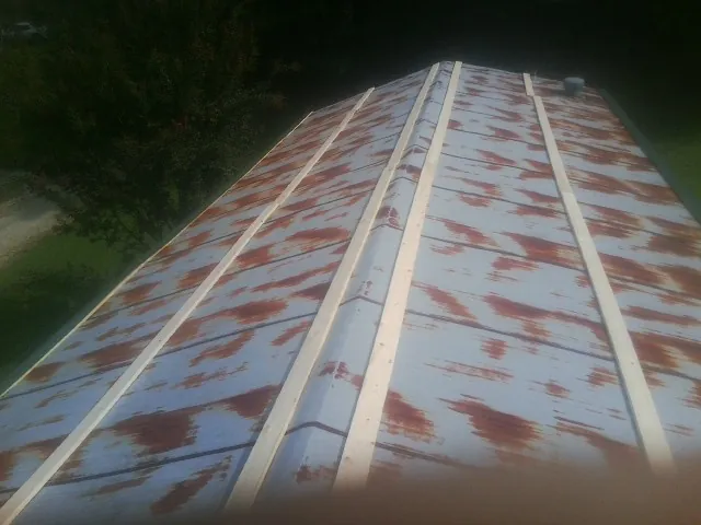 Rusted metal roof panels with new wood purlins before replacement — Storm Damage Roof Repair in Pomona by Roofing Brothers